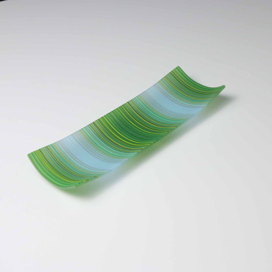 A decorative shallow rectangular boat shaped glass plate with raised corners and a  colourful ColourWave stripe patterns showing key colours of green and pale blue